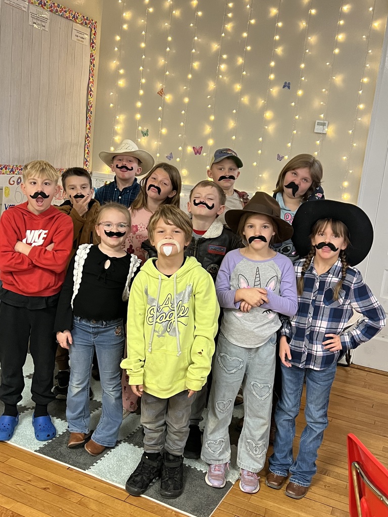 Group of students standing in front of the classroom wearing fake mustaches for red ribbon week
