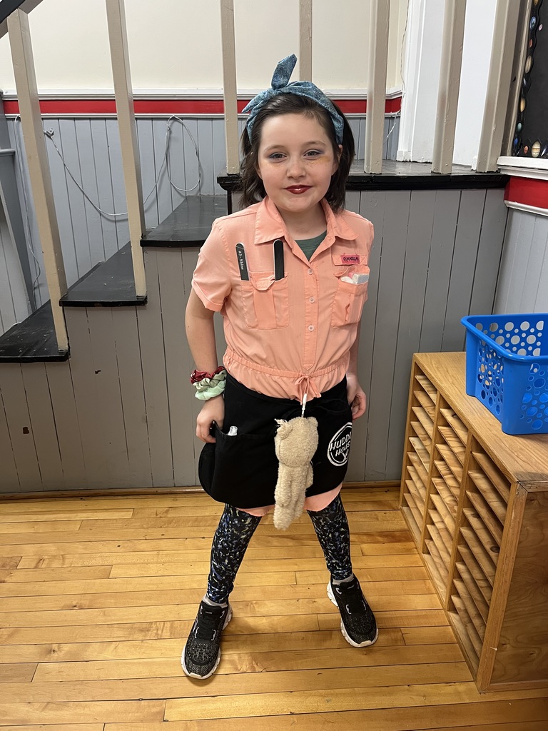 Female student standing in a stairwell dressed as a huddle house waitress for career day/ Red Ribbon Week