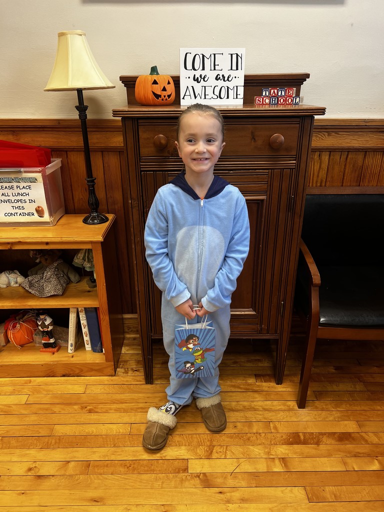 Student standing in front office holding a gift bag