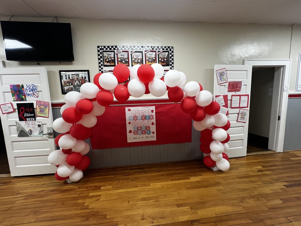 Two door decorated with collages decorated by children with a ballon arch in the middle