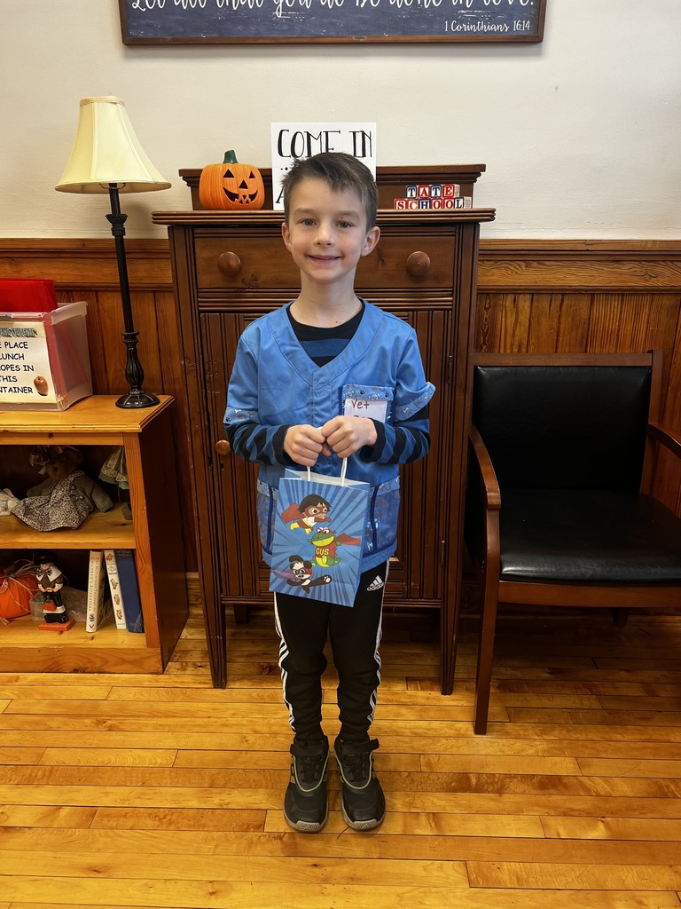 Student standing in front office holding a gift bag