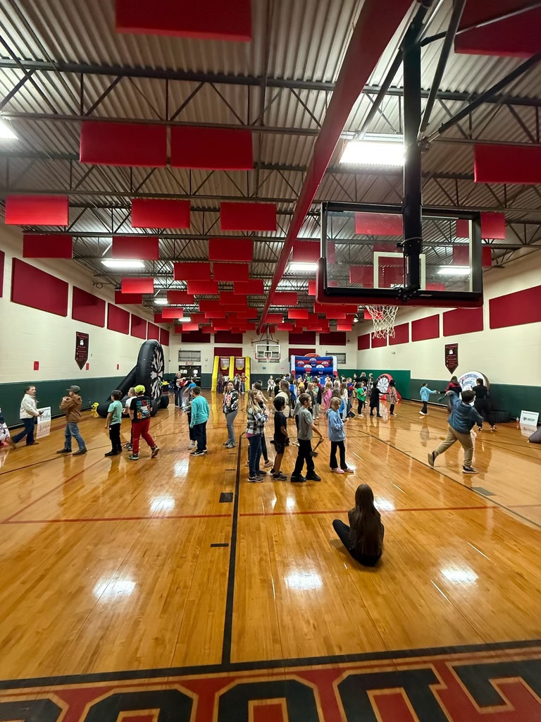 Group of kids in a school gym playing games at a fall festival 