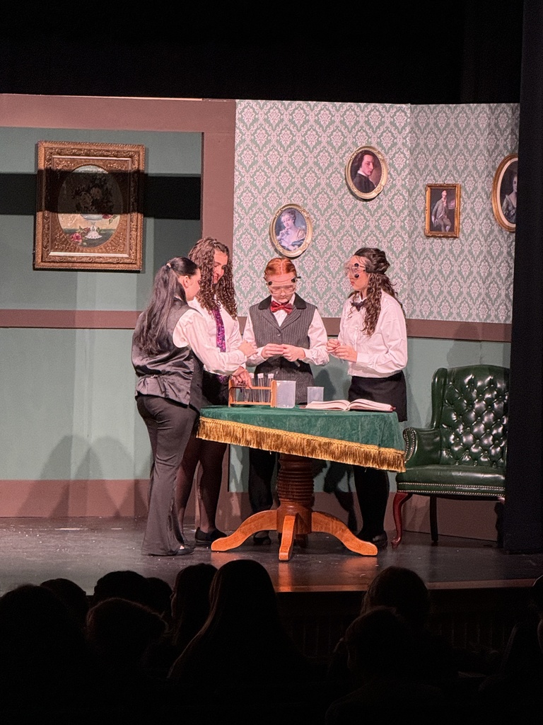 Four actors gathered around a table