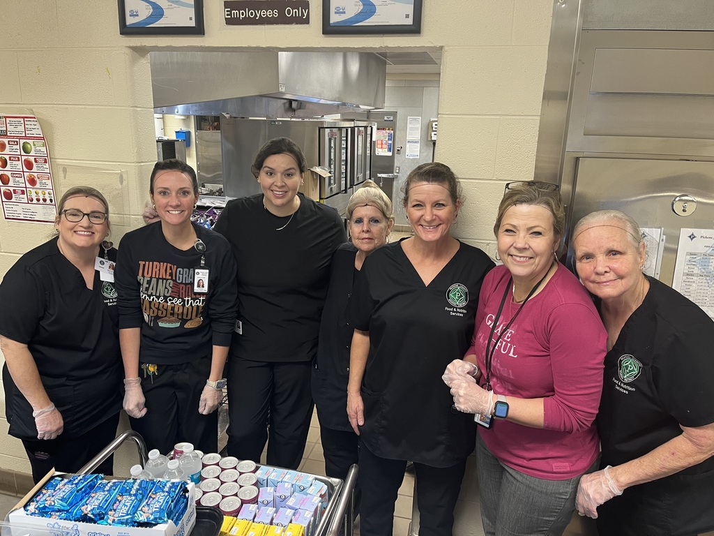 Cafeteria staff and administrators ready to start serving lunch to the students.