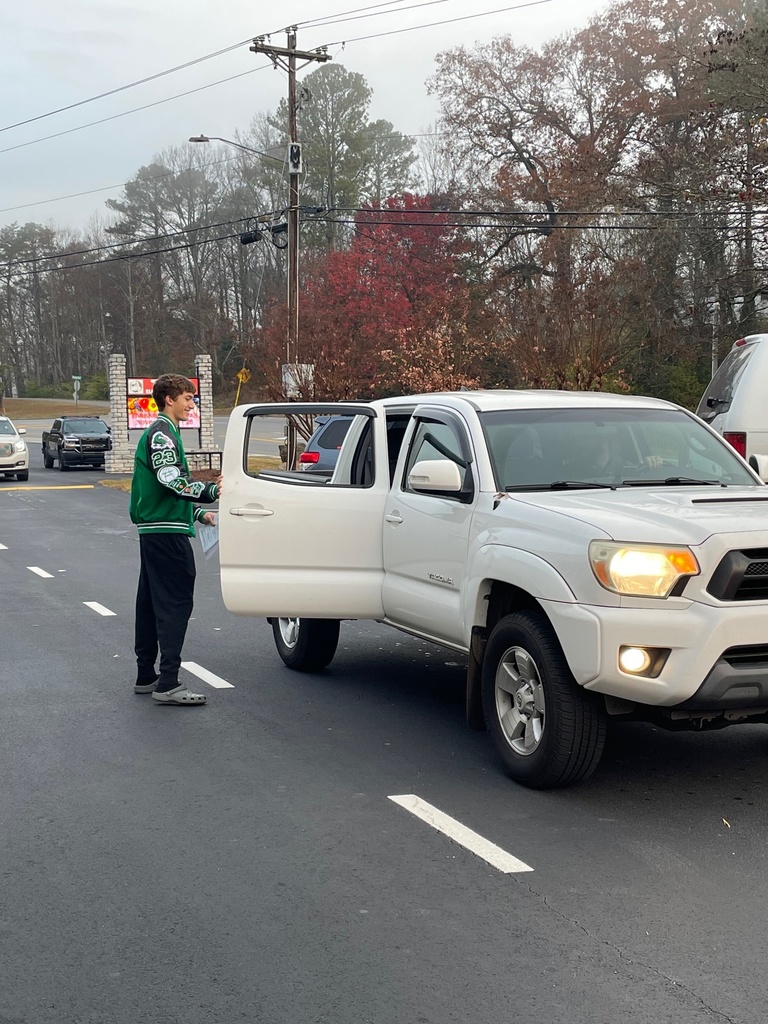 high school student standing beside a white truck with the passenger door open 