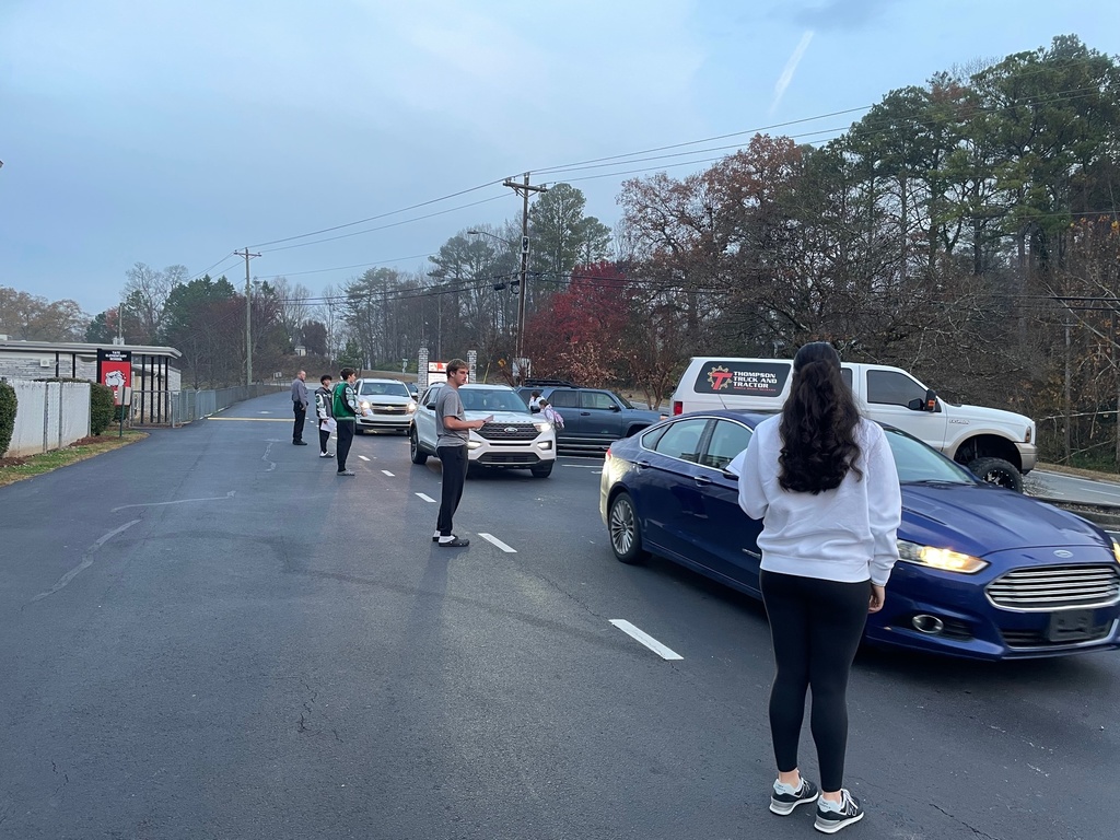 Group of high school student standing beside cars in school drop off line 