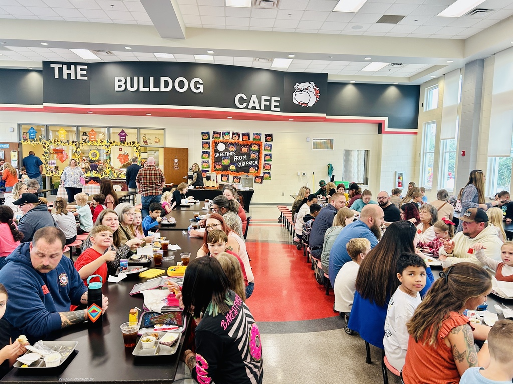 families sitting at lunchroom tables eating lunch