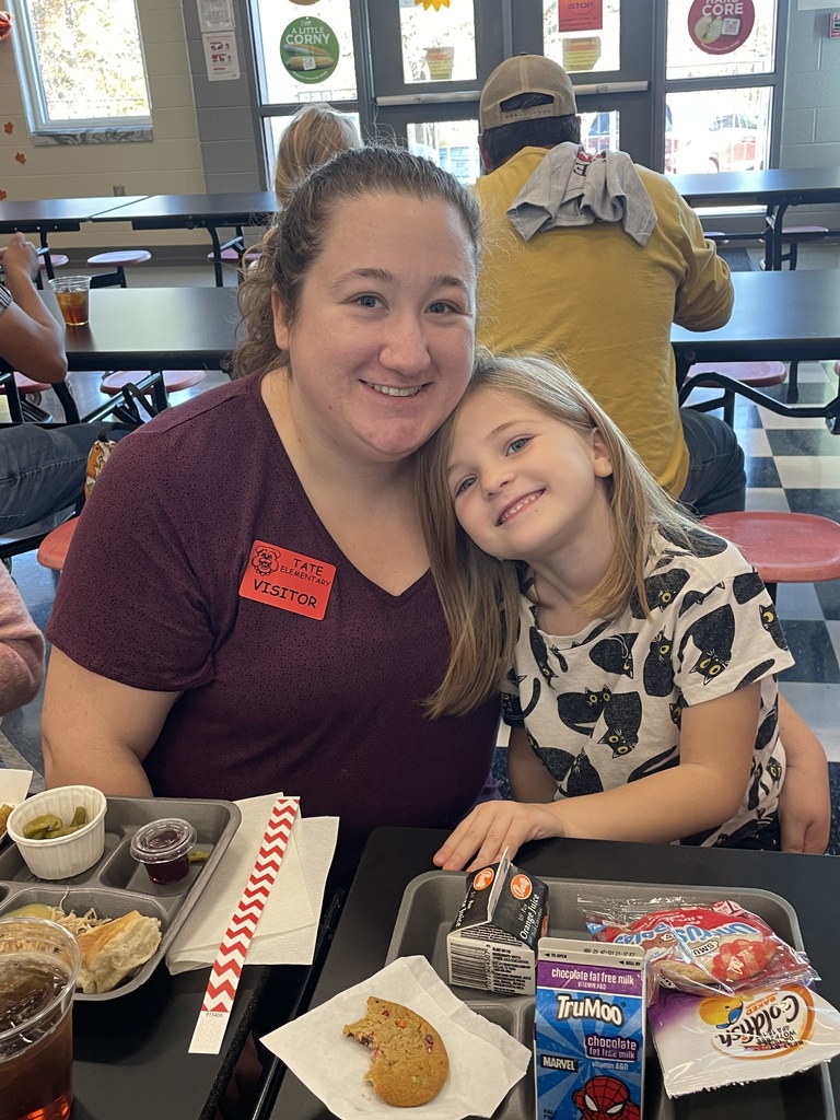 mother and child sitting at a lunchroom table eating lunch