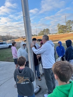 Students and Coach Raymond getting ready to raise the flag