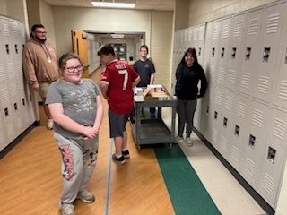Students in hallway with cart full of packages