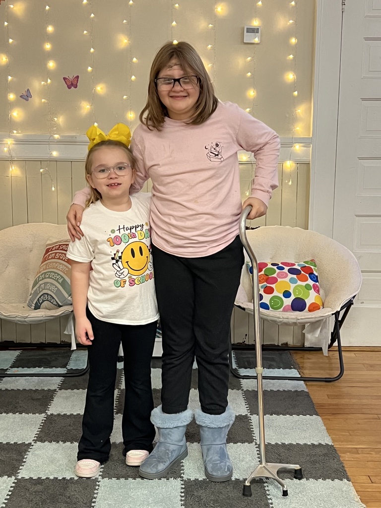 Two students wearing glasses one is holding a cane