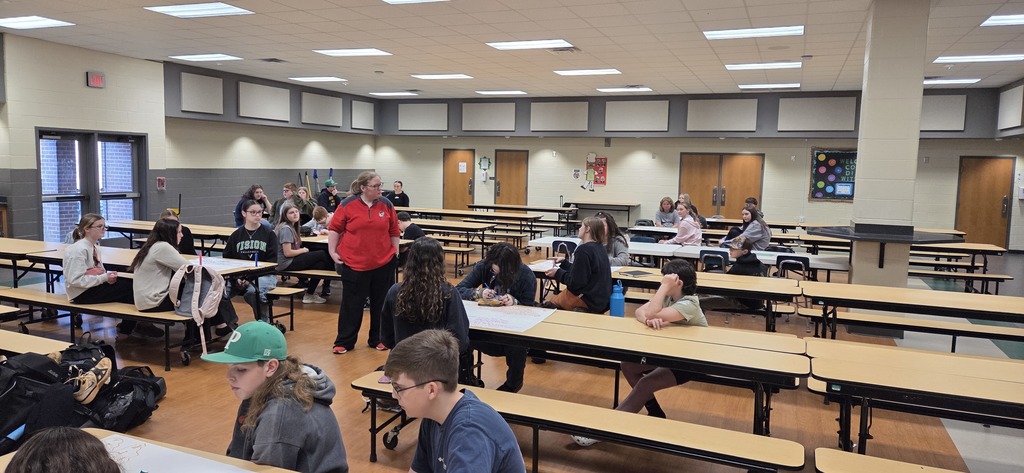 Students sitting at tables in the cafeteria