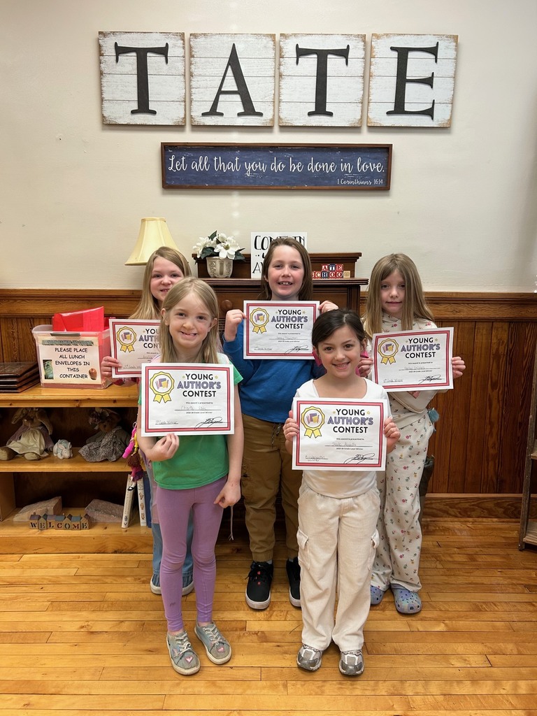 5 kids standing in a room holding certificates. 