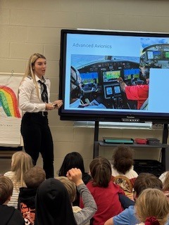 Female Airplane Pilot presenting to a group of students