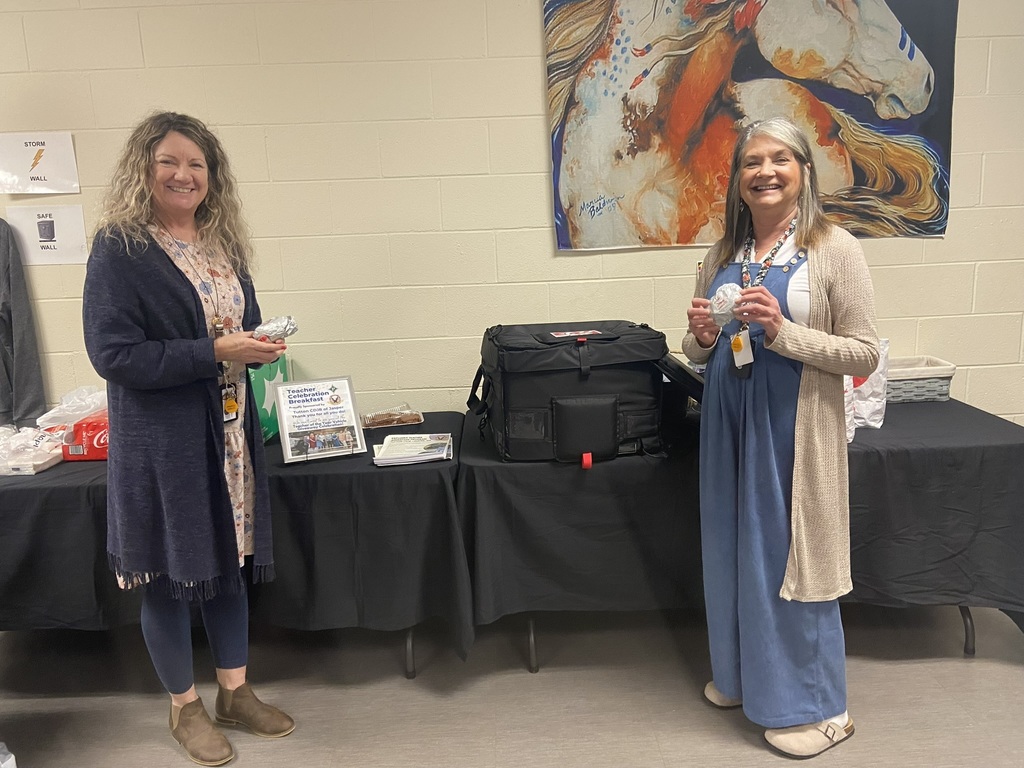 Dana Stone and Gail Perritt holding biscuits in front of a table