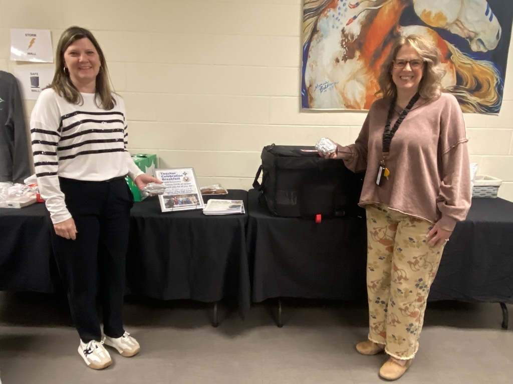 Kim Hamilton and Lori Holbert in front of biscuit table.