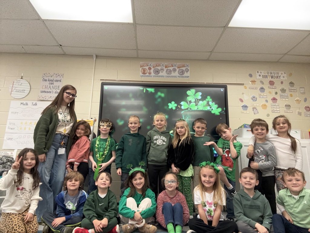 group of students and female teacher most of them are wearing green