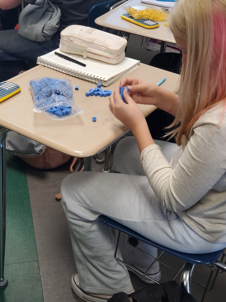 Side view of student at desk working with snap cubes