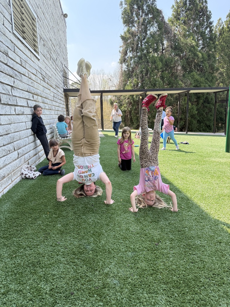 Two people on  a playground doing a hand stand