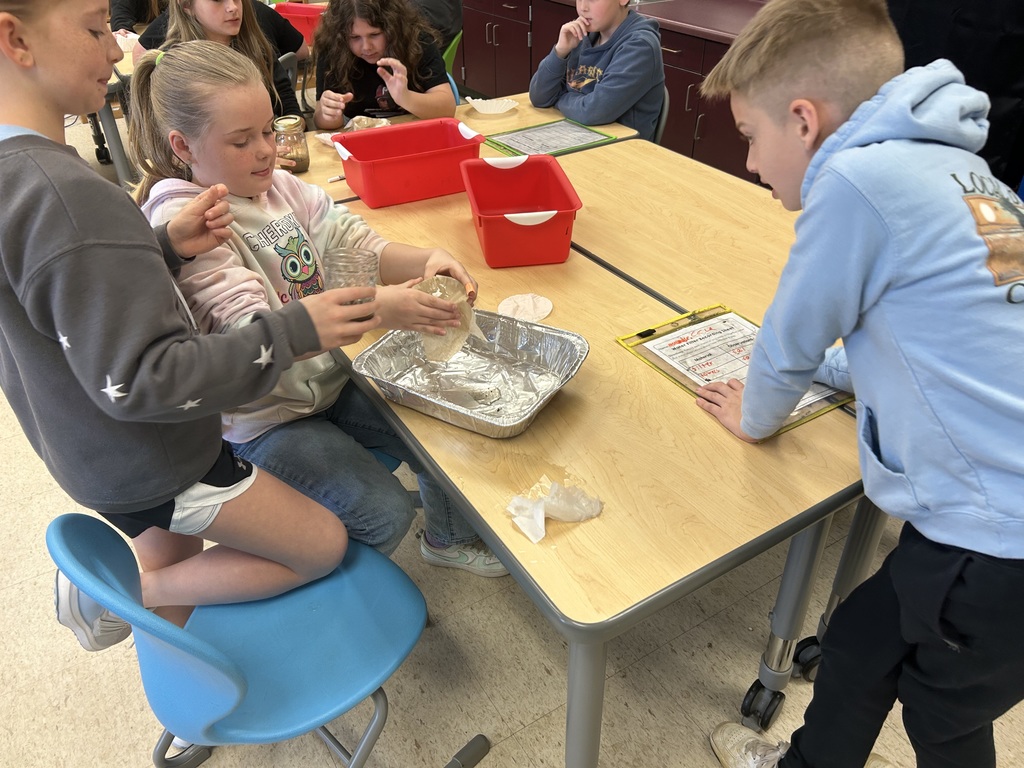 Fourth-graders testing materials and designing a water filter in STEM Lab.