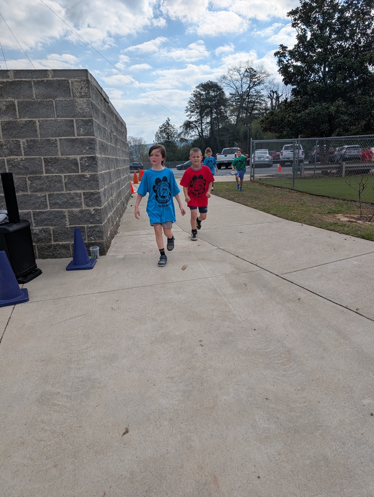 Two male students running inside colorful cones