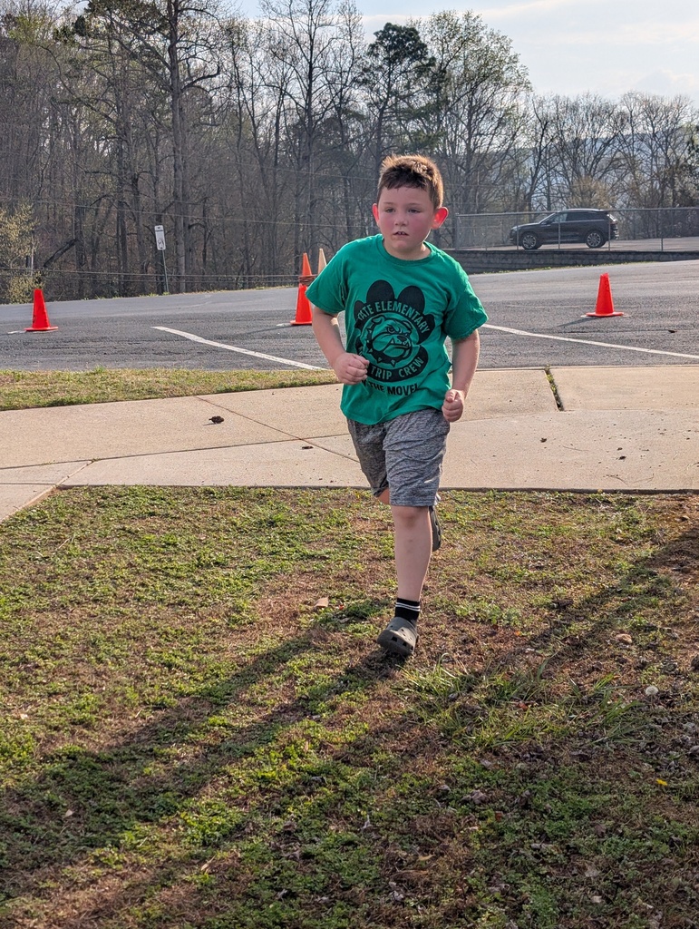 male student running inside colorful cones