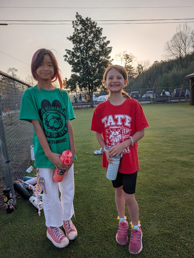 Two female students standing holding water bottles
