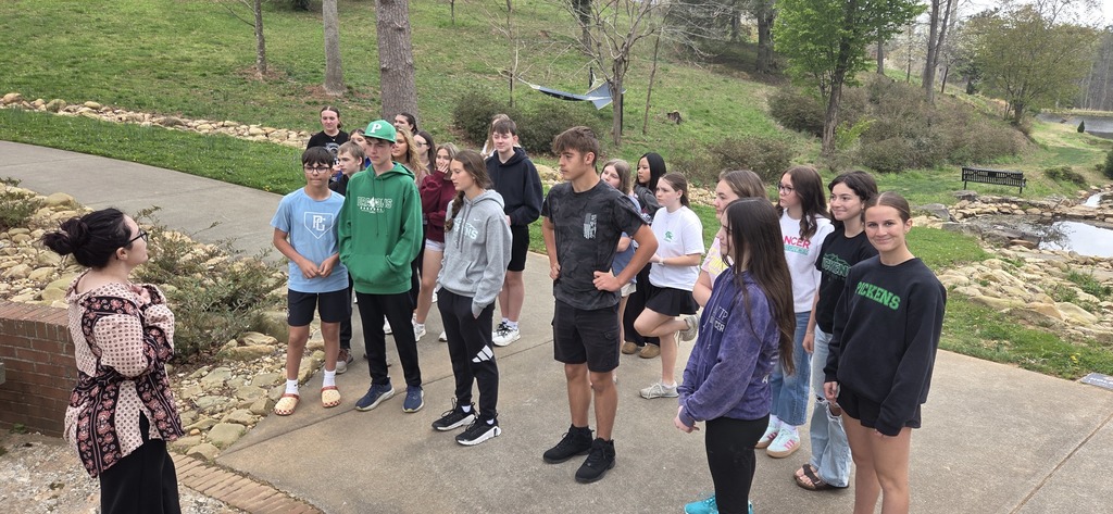 Group of students on a sidewalk listening to the tour guide