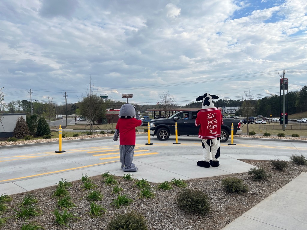 a cow costume and a bulldog costume at a drivethru