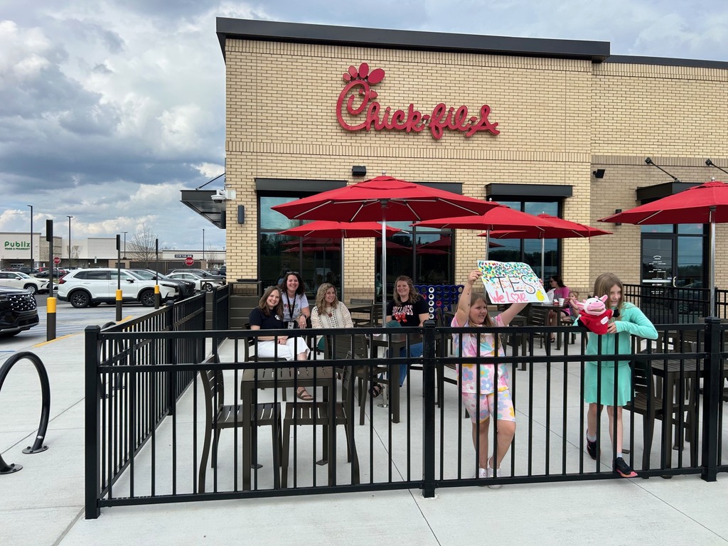people standing in front of chick fil a building