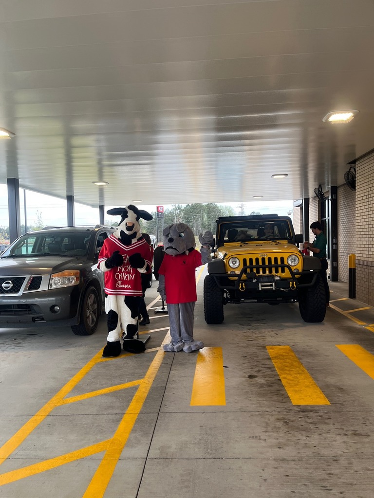 a cow costume and a bulldog costume at a drivethru