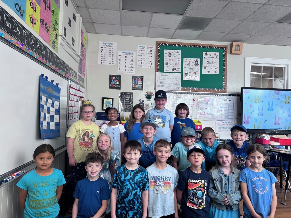 Group of kids in a classroom all  wearing blue