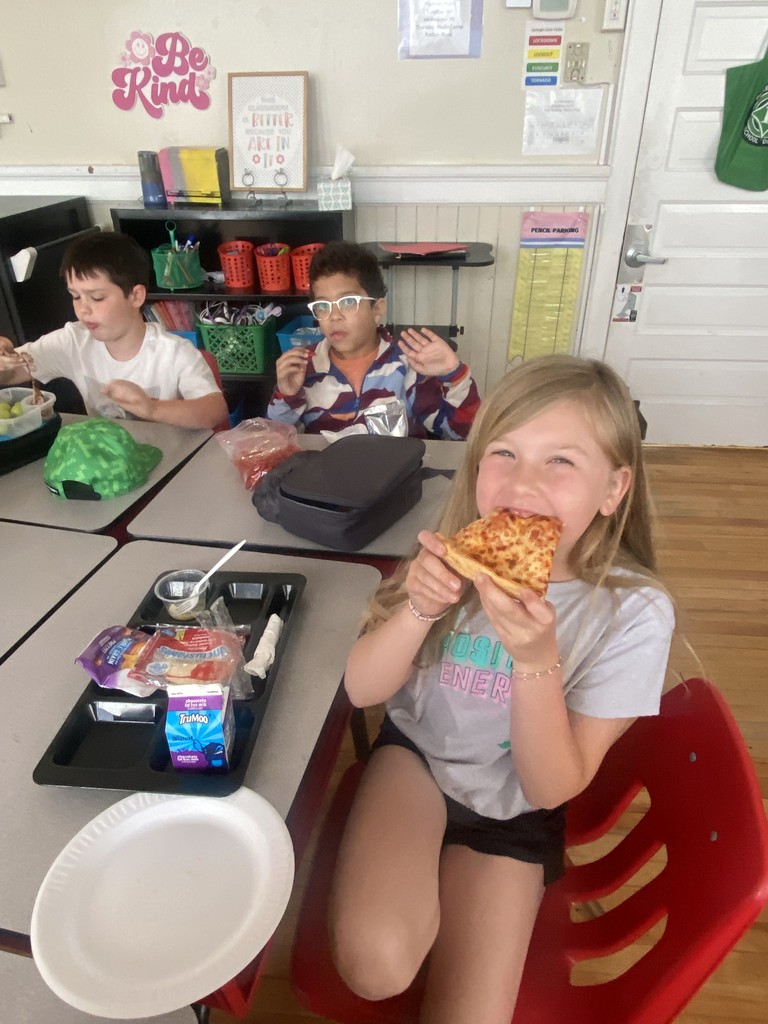one girl and two boys eating pizza
