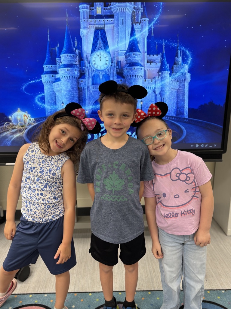 Three kids wearing mickey and minnie mouse ears. They are standing in front of Cinderella's castle projected on a screen.