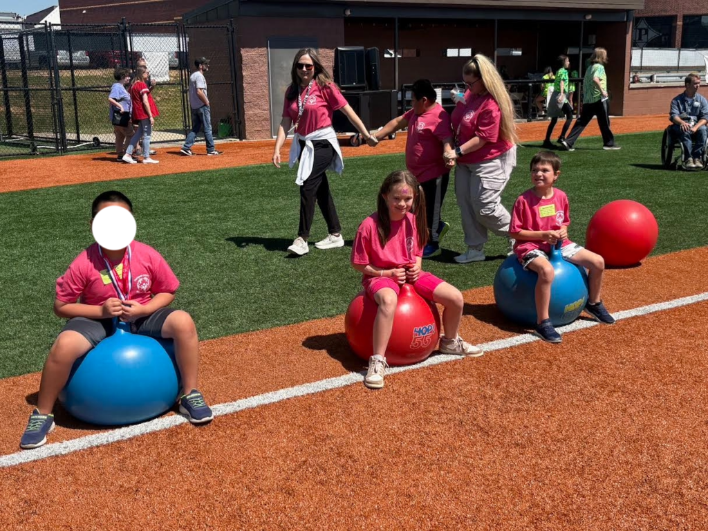 Kids outside. Three kids are sitting on bouncy balls