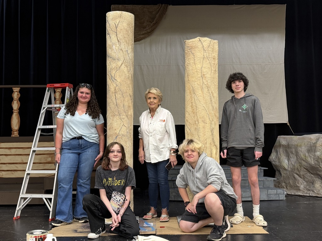 4 students and Ms. Warner with marbled columns