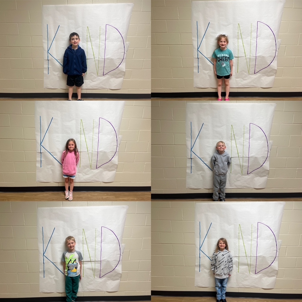 Kids standing in front of a poster with the letters  K N D. Their body is being used as the letter I