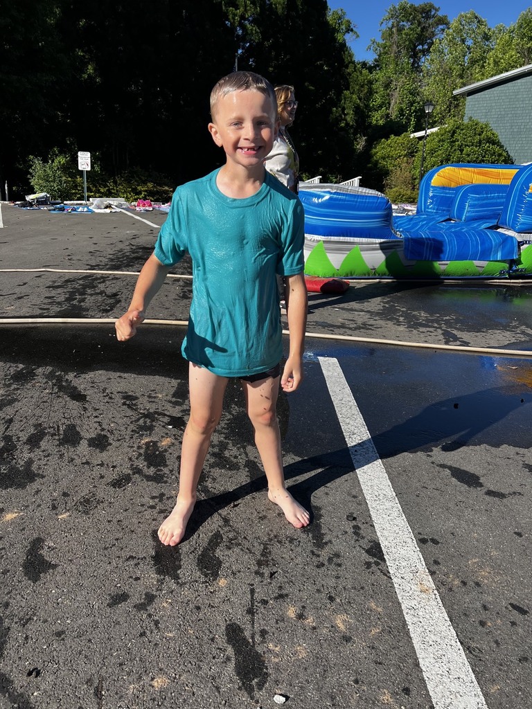 One small child standing. He is wet and smiling