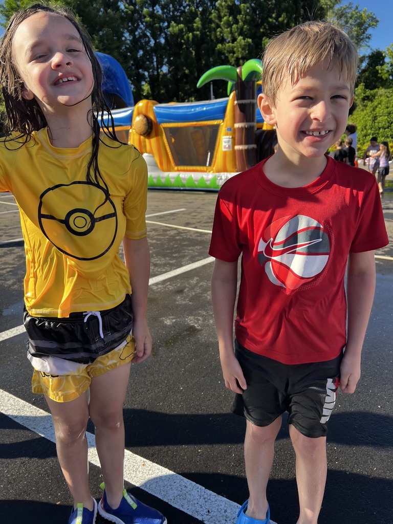 Two small children standing. They are wet and smiling