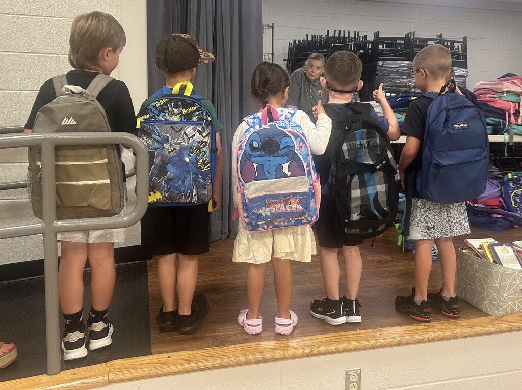 Students choosing backpacks donated by Hallyboy Foundation.