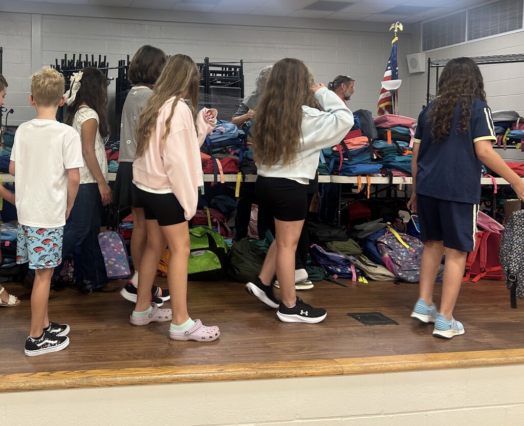 Students choosing backpacks donated by Hallyboy Foundation.