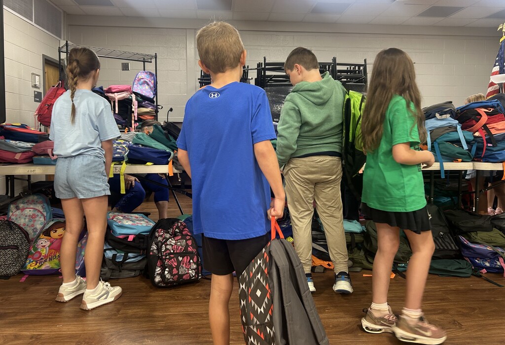 Students choosing backpacks donated by Hallyboy Foundation.