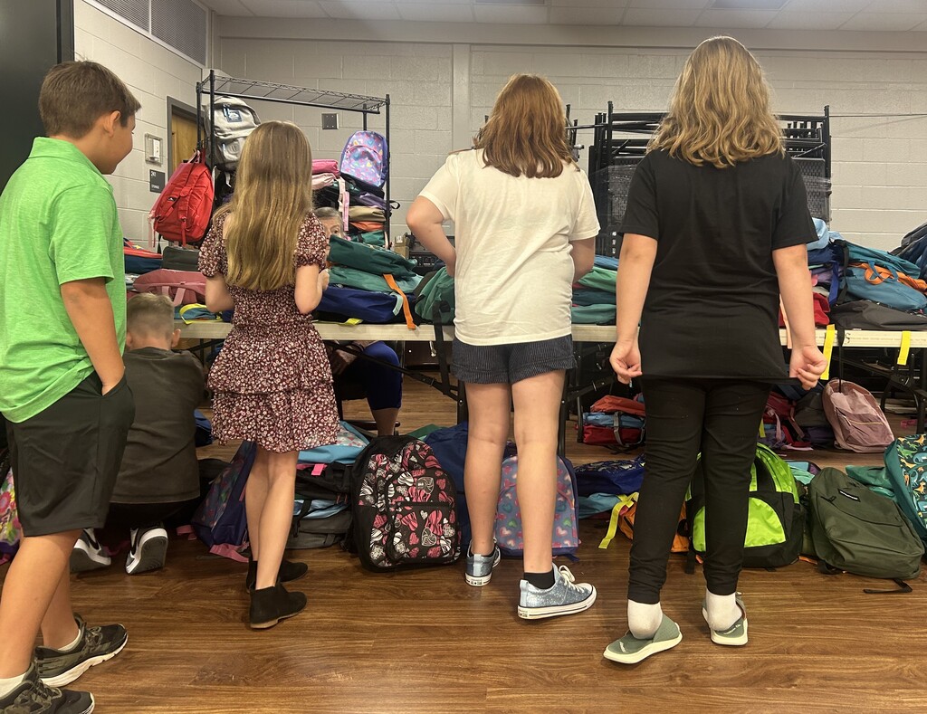Students choosing backpacks donated by Hallyboy Foundation.