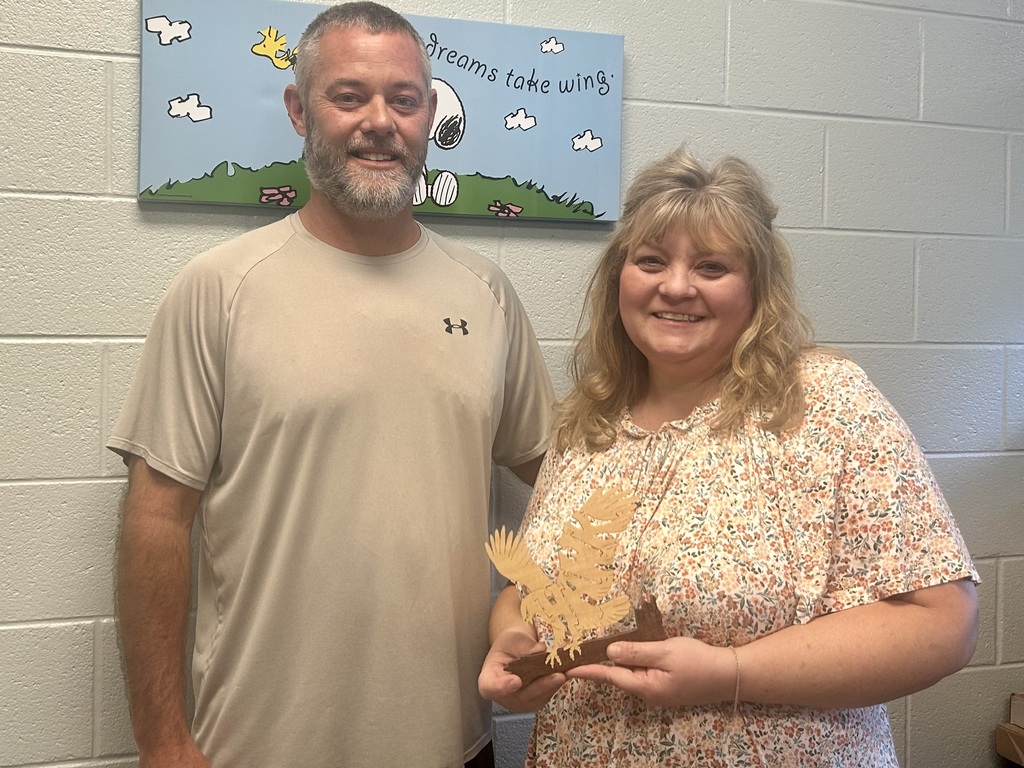 Coach Black is passing the Hawk award to our amazing bookkeeper, Susie Chapman!