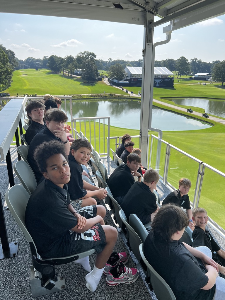 Students watching a golf event from the stands