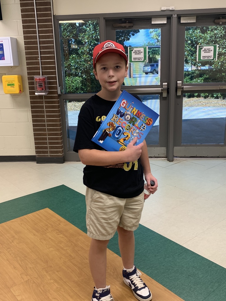 Student displaying the book he chose from the table