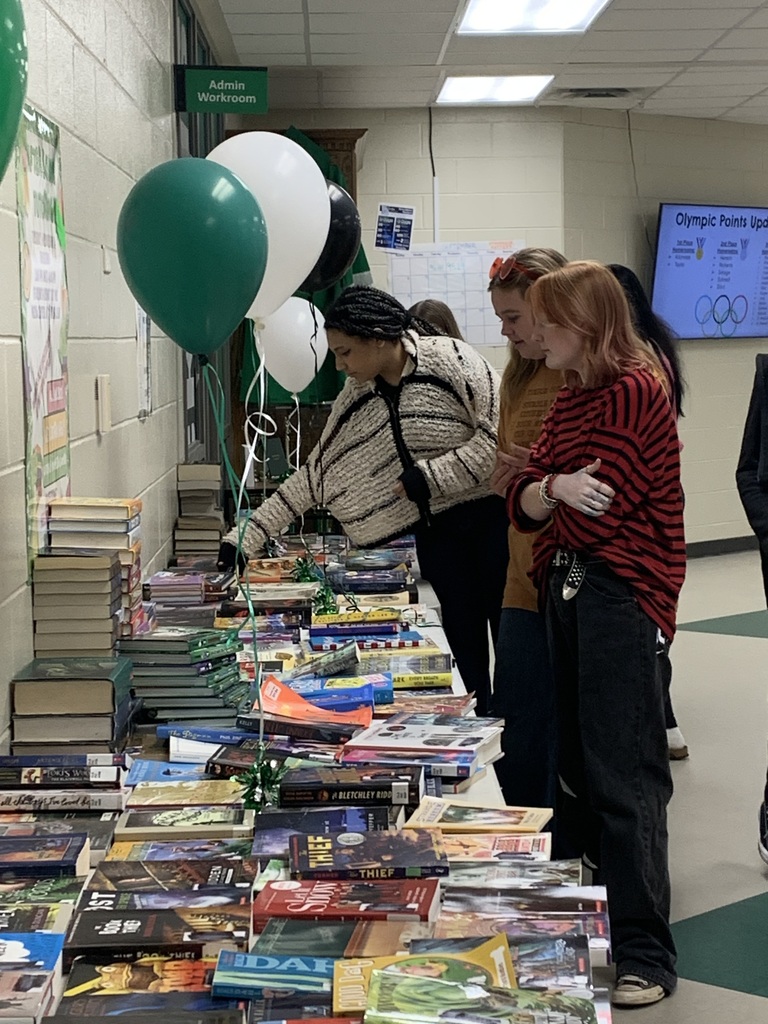 Students choosing books from the book share table