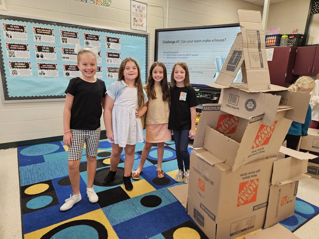 3rd grade girls building cardboard tower.