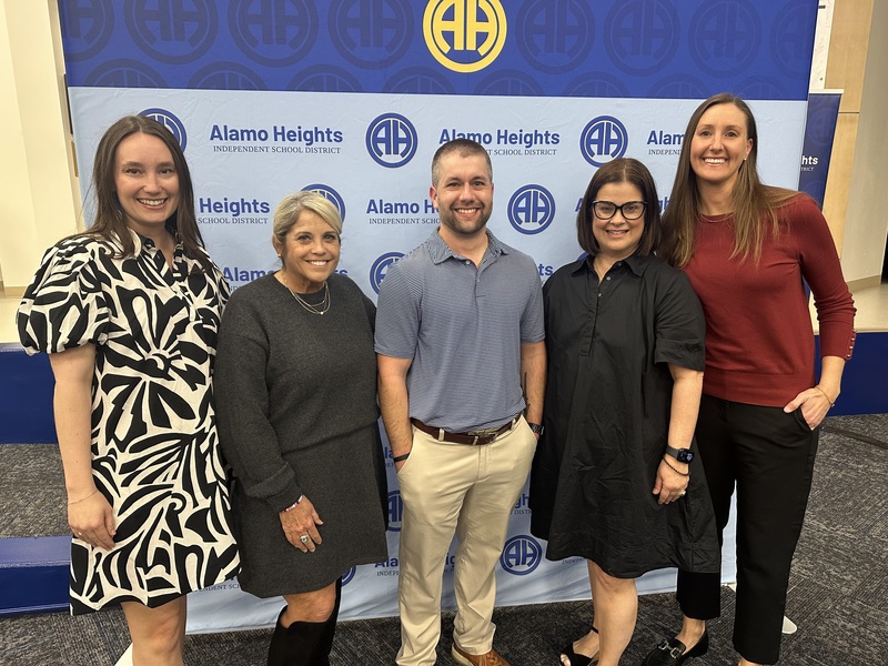 Five teachers of the year pose in front of banner