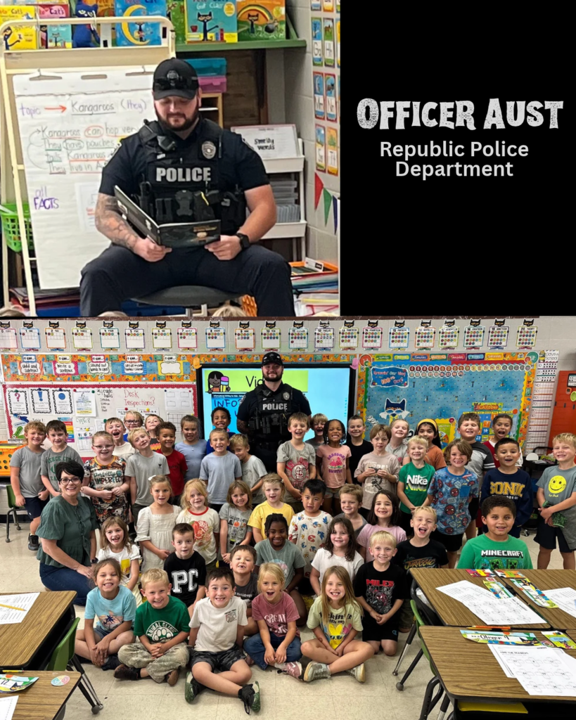 police officer reading in front of a group of children